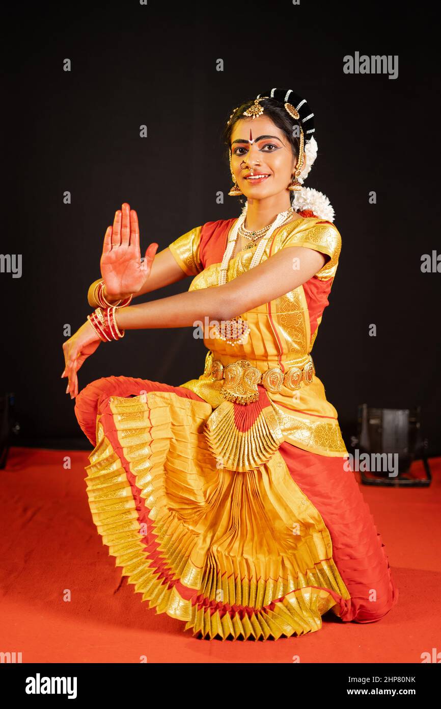 Traditional bharatanatyam dancer showing hand gesture or shiva pose on performance at stage - concept of mudra or asana, indian culture and classic Stock Photo