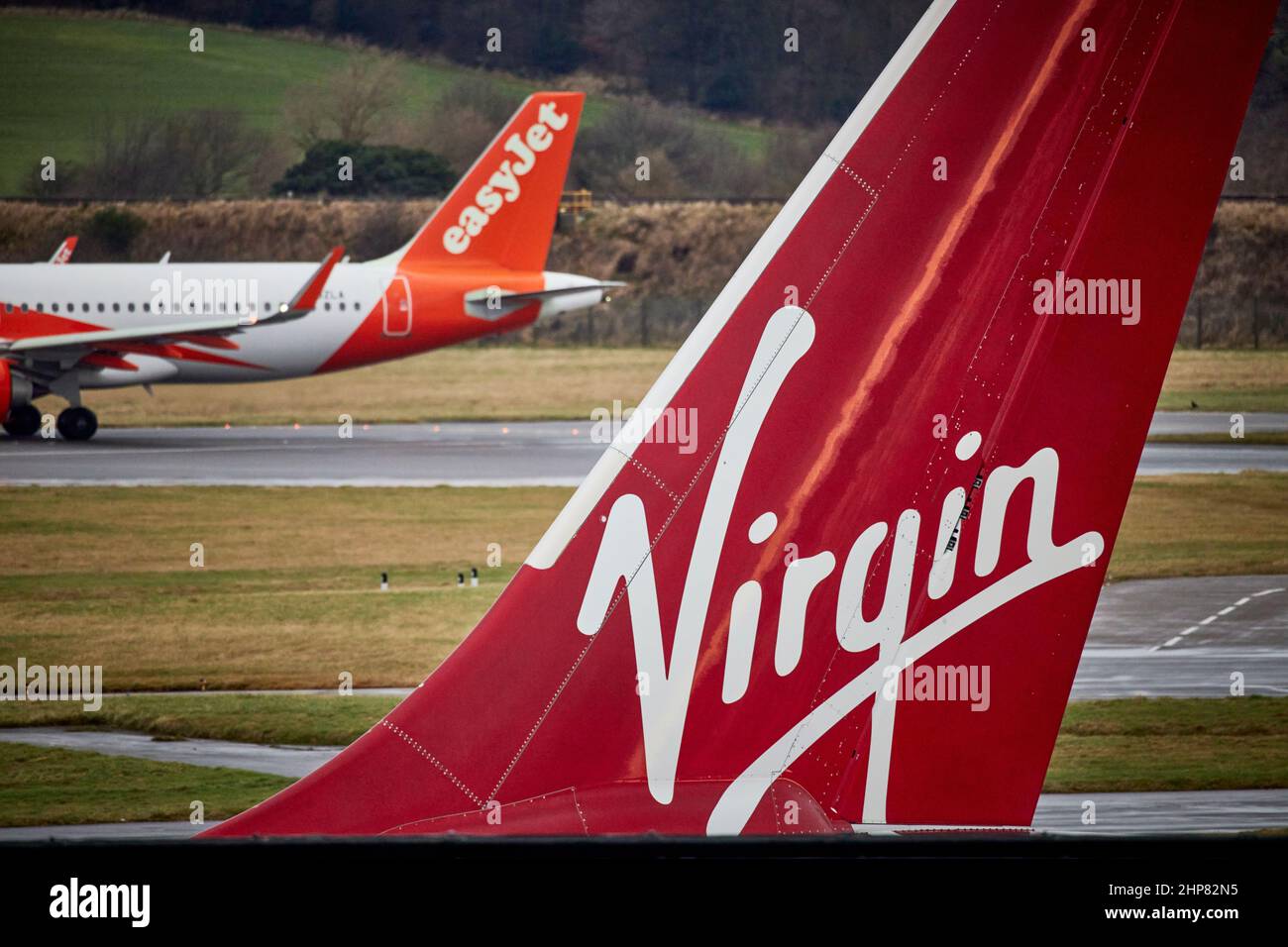 Edinburgh Airport Virgin Atlantic Airbus A330 tail-fin from jet airliner plane named Uptown Girl and Easyjet  G-UZLA. Airbus A320-251N Stock Photo