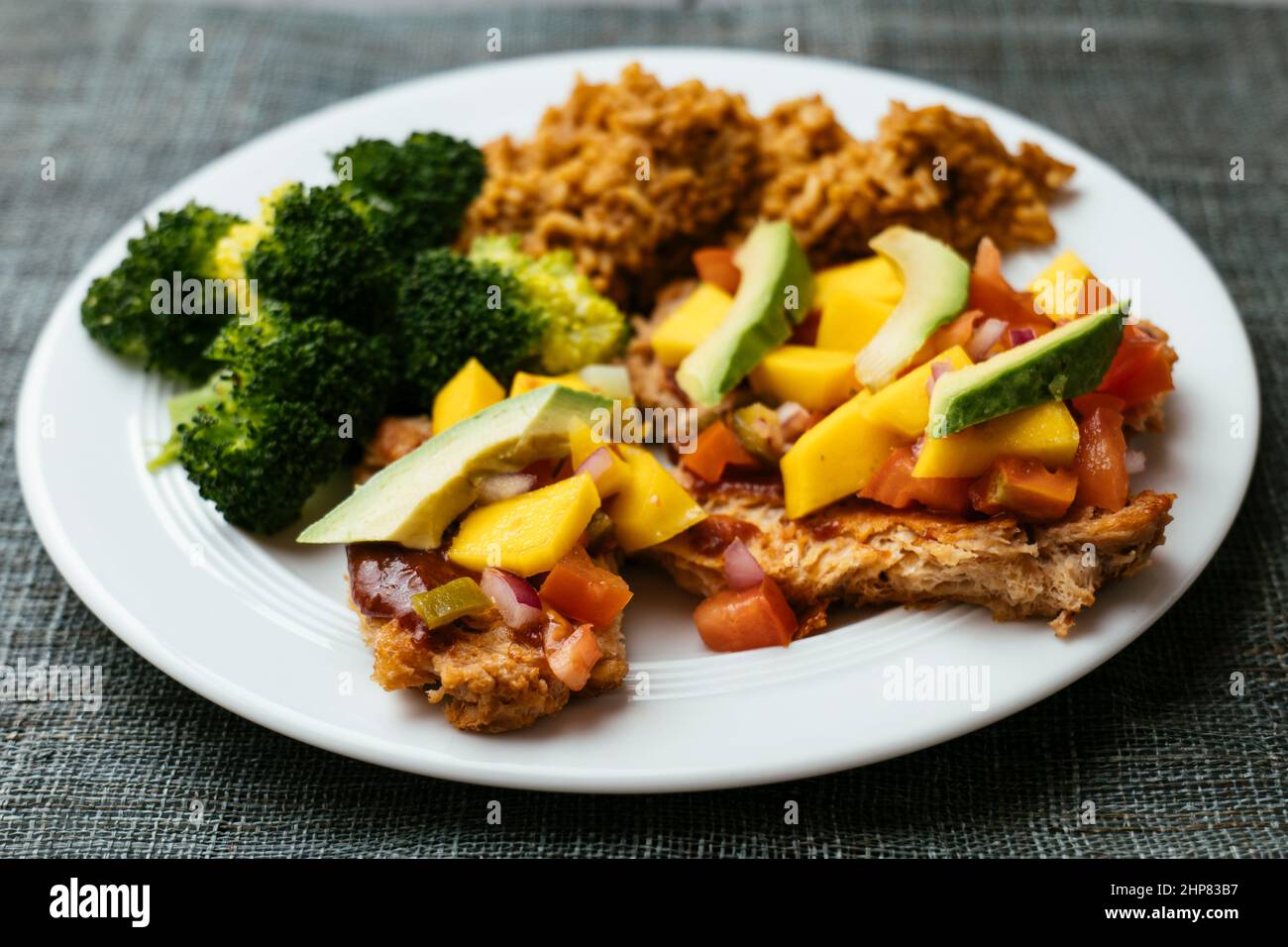 Spicy TVP Cutlets with Mango Salsa, Mexican Rice and Broccoli Stock Photo