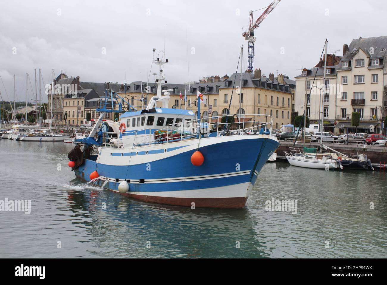 a big fishing boat is navigating out of the harbour in dieppe towards open sea for fishing at scallops in september Stock Photo
