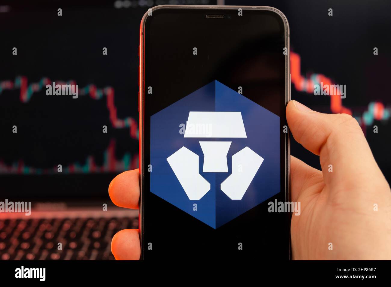 Monaco MCO app of cryptocurrency stock market analysis on the screen of mobile phone in man hands and downtrend charts trading data on the background, February 2022, San Francisco, USA. Stock Photo