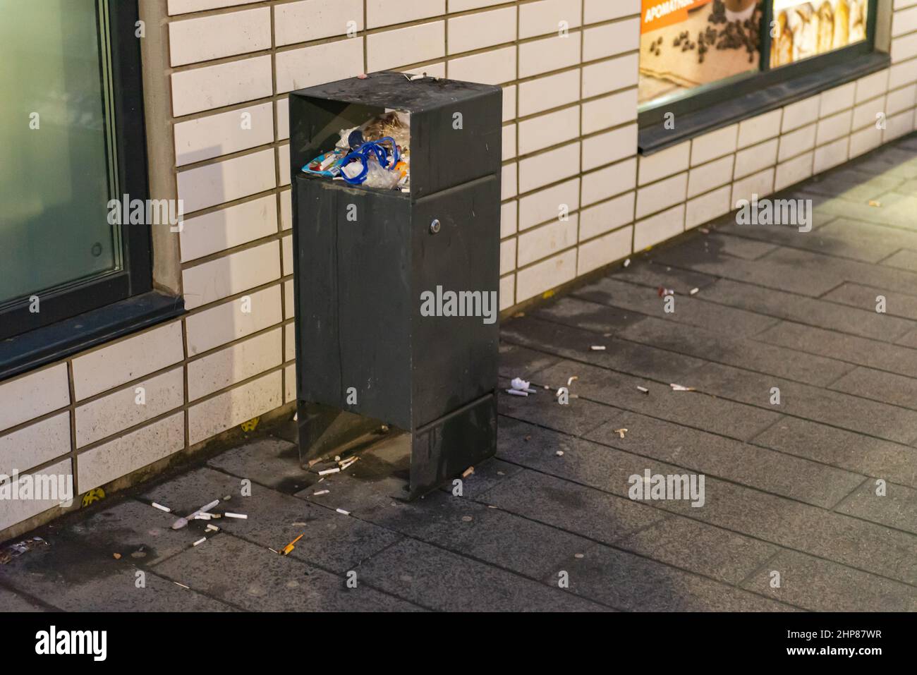 Garbage bins in the yard. An overflowing urn near the entrance of an