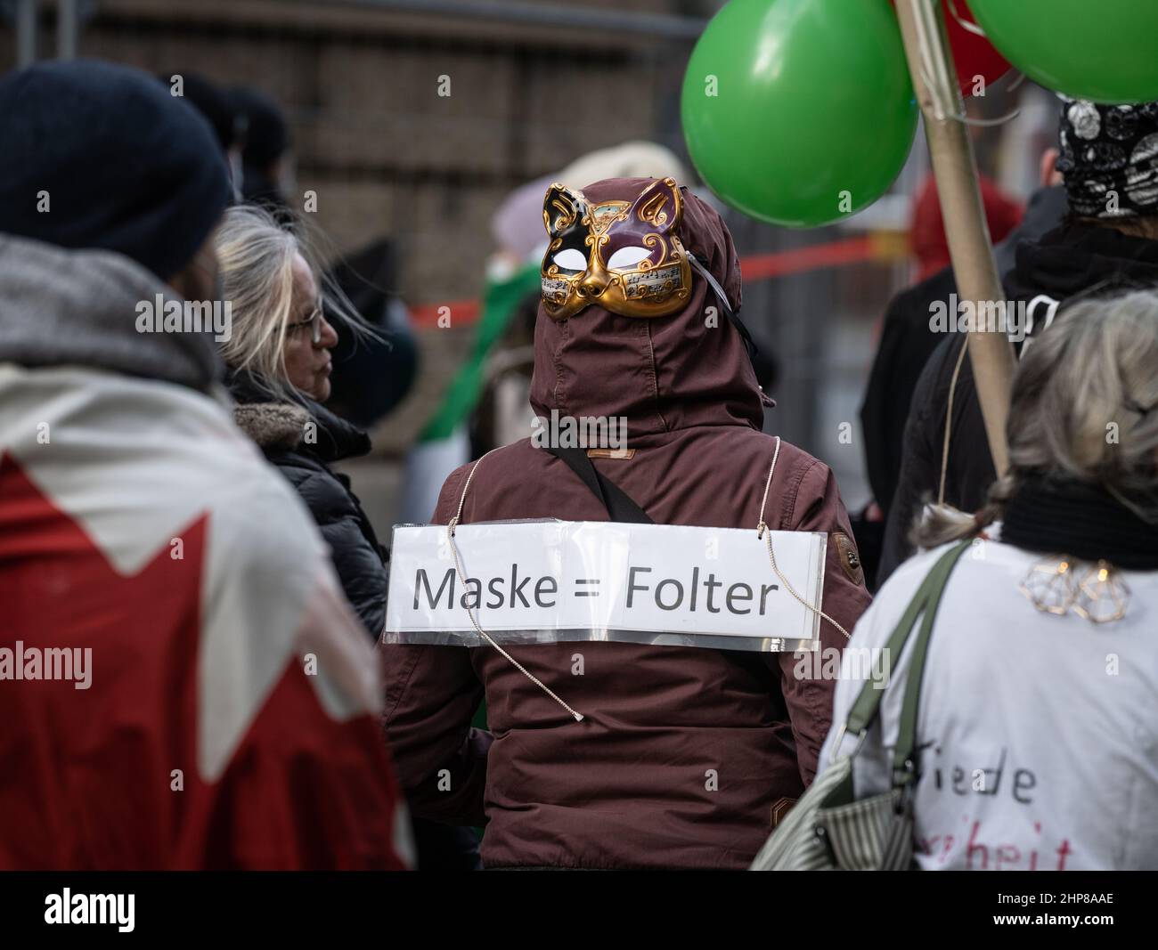 19 February 2022, Hessen, Frankfurt/Main: A woman wears a mask on the back of her head and a placard reading "Mask = Torture" at a demonstration of several thousand people against corona measures and mandatory vaccination in downtown Frankfurt. Photo: Frank Rumpenhorst/dpa Stock Photo