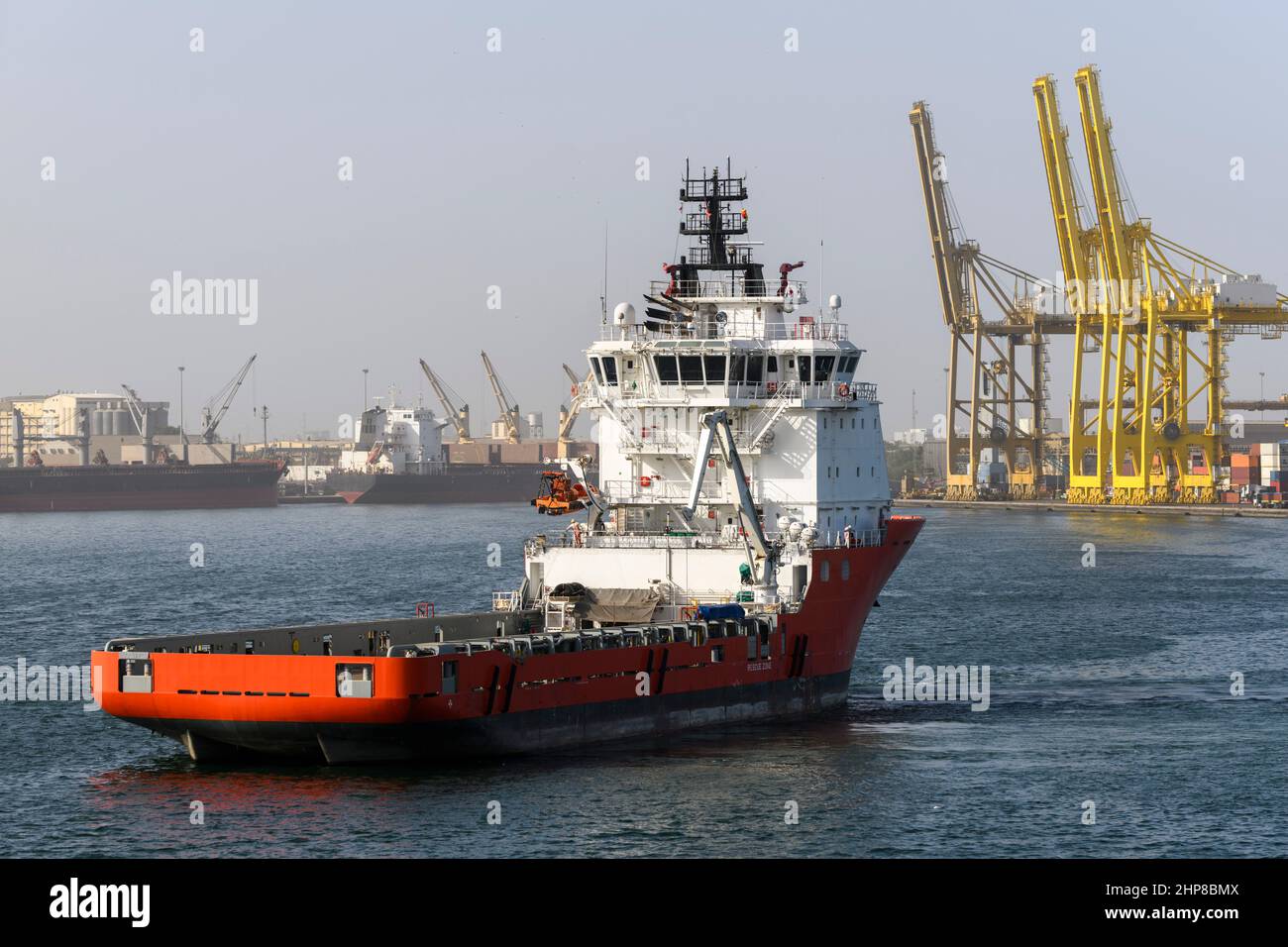 Big orange offshore supply vessel in the port. AHTS ship. Stock Photo