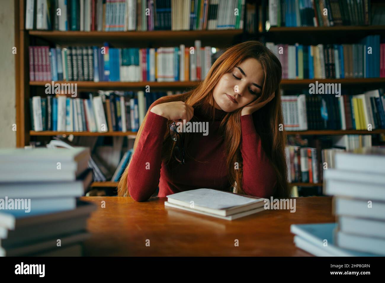 A girl holding a book shelf, student in the library Stock Photo - Alamy
