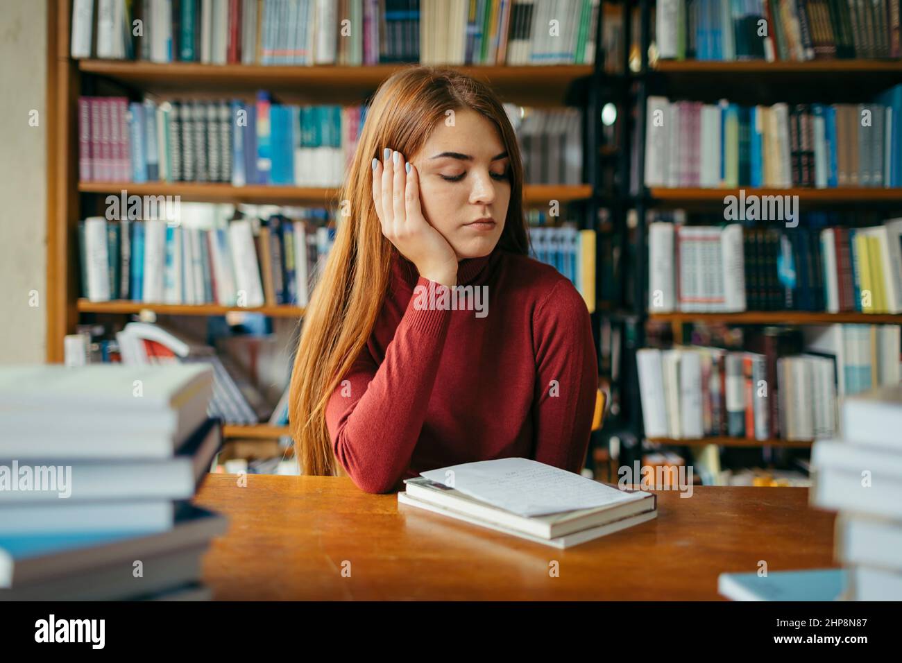 A girl holding a book shelf, student in the library Stock Photo - Alamy