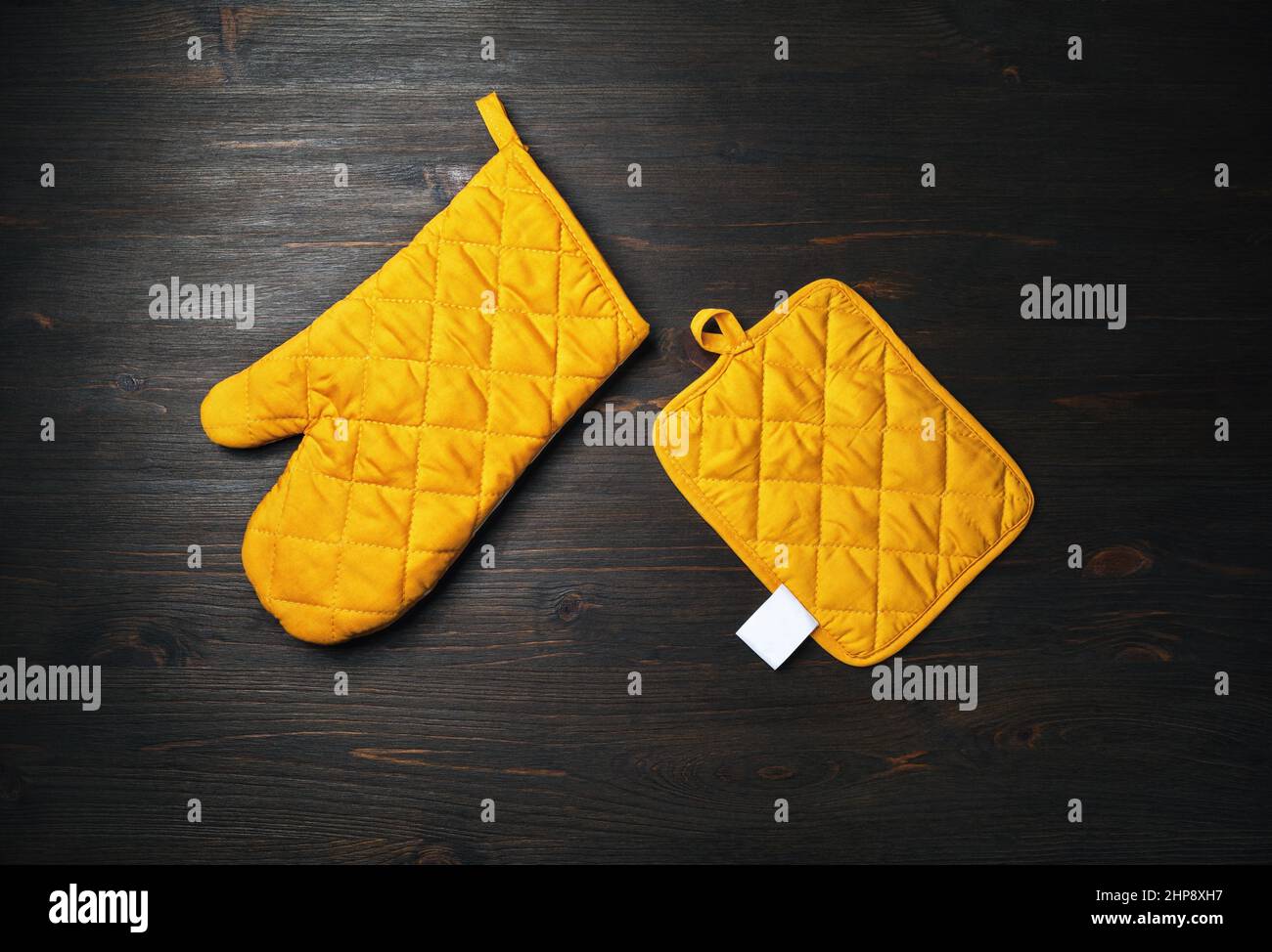https://c8.alamy.com/comp/2HP8XH7/oven-mitt-and-potholder-on-wooden-background-kitchen-accessory-cooking-mitten-oven-glove-flat-lay-2HP8XH7.jpg