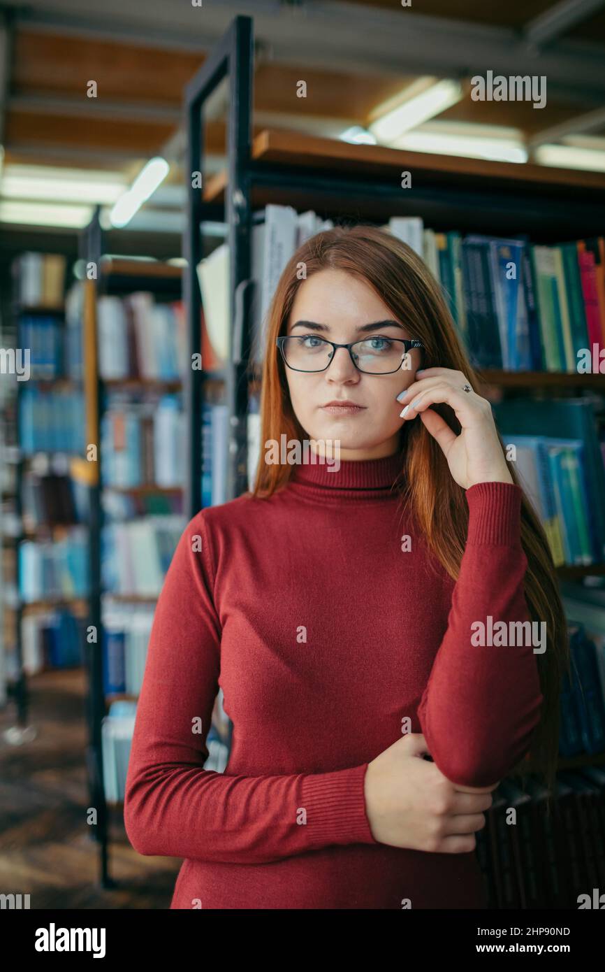 A girl holding a book shelf, student in the library Stock Photo - Alamy