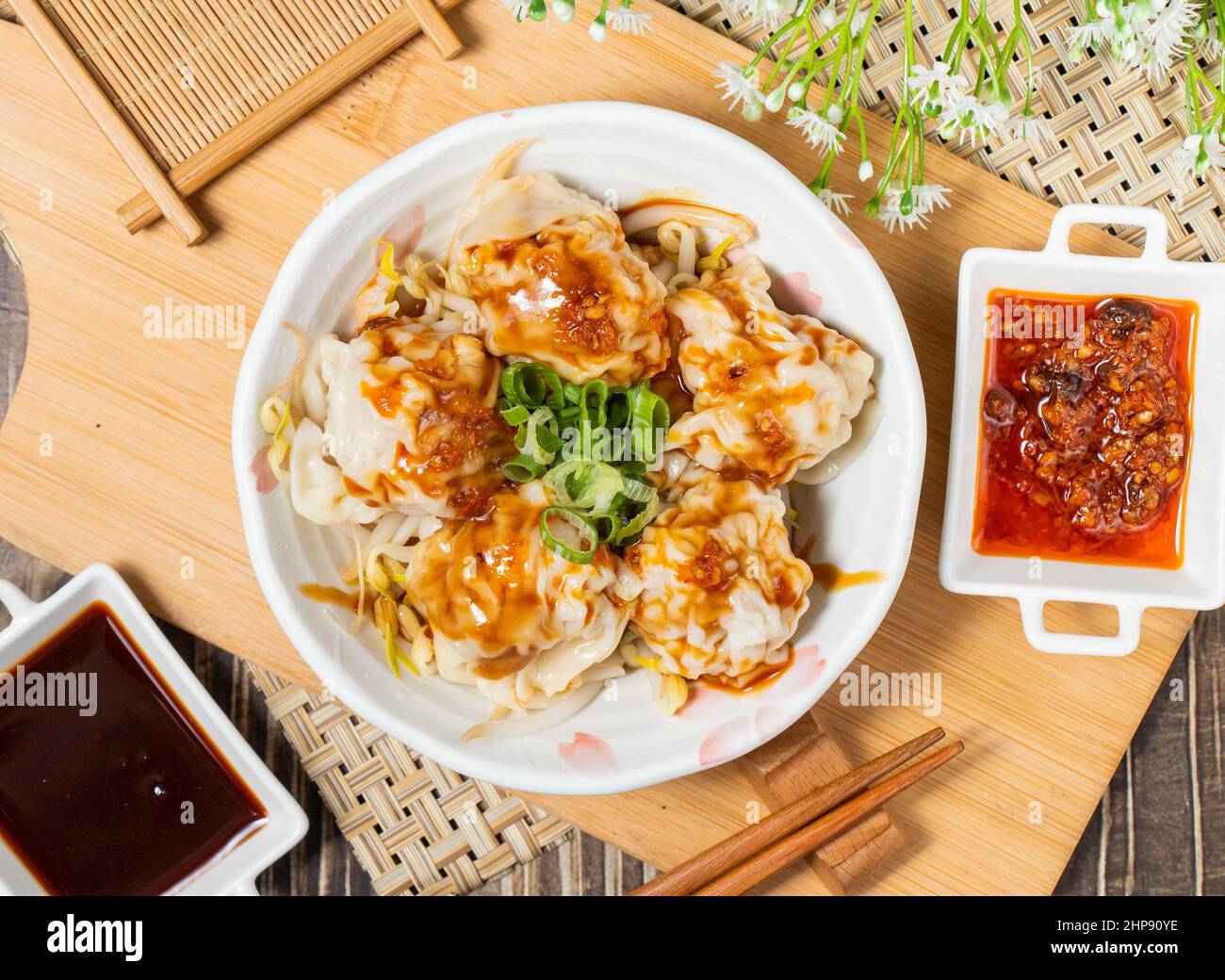 Stir-fried Hands with Fresh Meat and Red Oil with sauce isolated on wooden cutting board top view Stock Photo