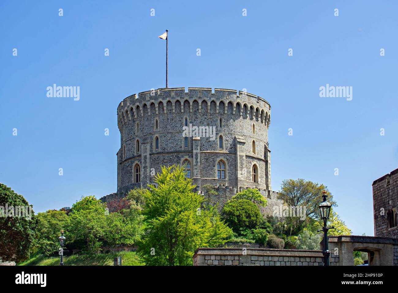 The Round Tower of Windsor Castle. A motte and bailey style fortification topped with a keep.  Windsor, Berkshire, England. A flag stands at full mast Stock Photo