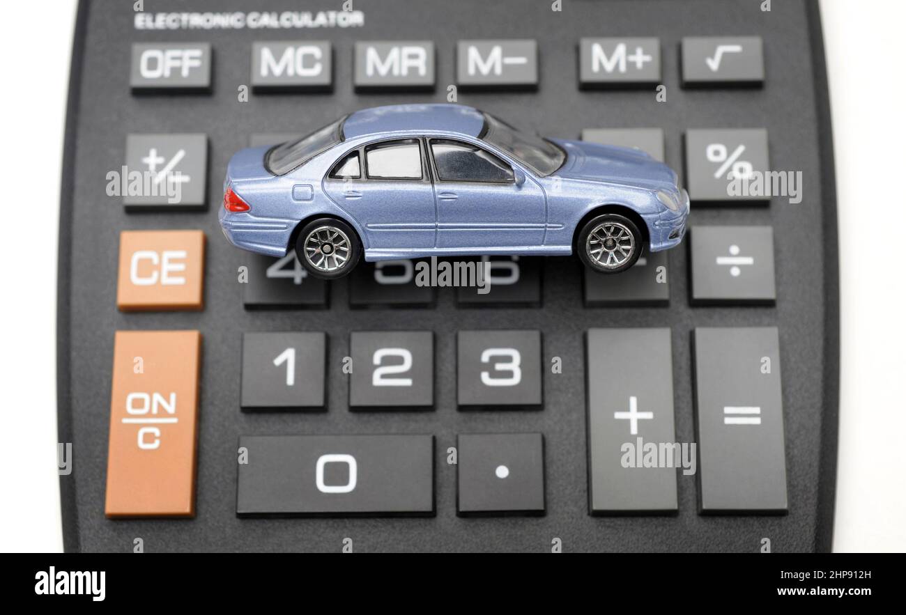 MODEL CAR ON CALCULATOR RE INSURANCE COSTS BUYING REPAIRS TAX EMISSIONS ETC UK Stock Photo