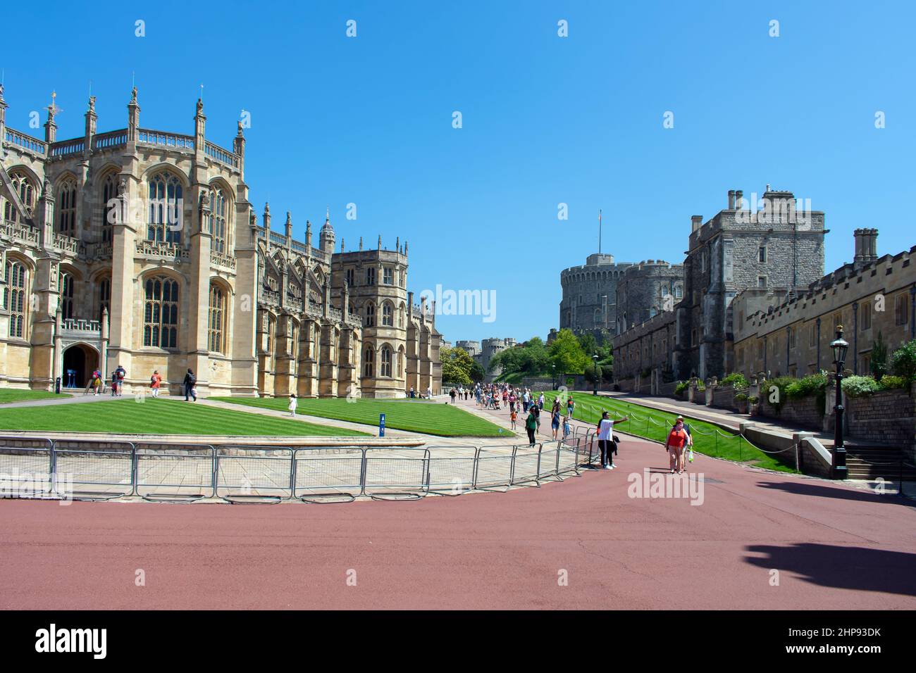 St Georges Chapel and the Round Tower seen from the Lower Ward in Windsor Castle, UK. Metal Barriers line the edge of the pathway as visitors tour. Stock Photo