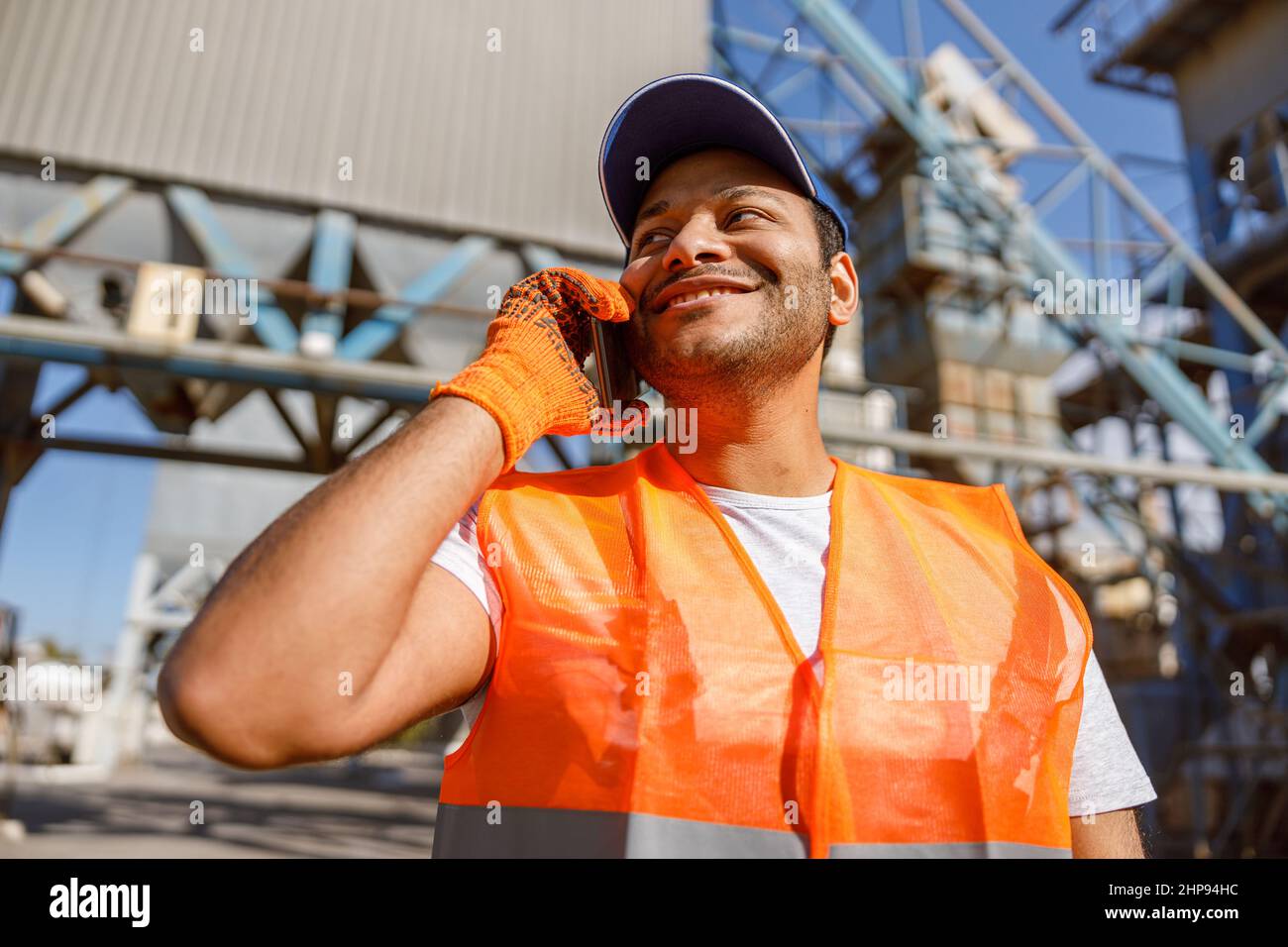 Multiethnic engineer talking on cellphone on construction site Stock Photo
