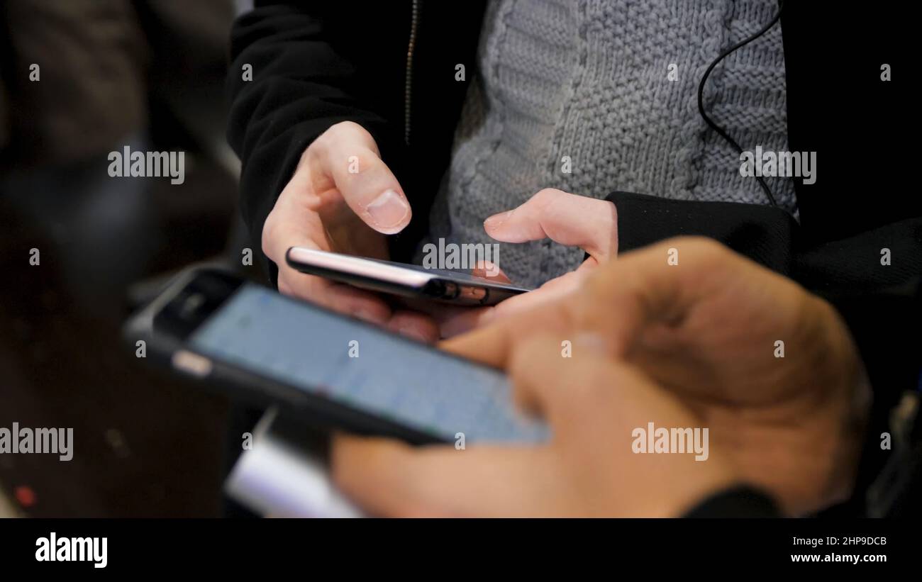 Close-up of smartphones in hands of two young men . New generation in a cafe in close up. Communication concept. Couple using digital gadgets for onli Stock Photo