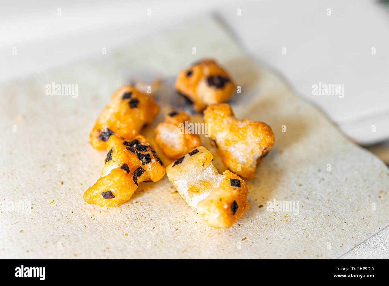 Traditional Japanese food on airplane flight with salty nori rice crackers on recyclable green tea napkin macro closeup showing texture of healthy bak Stock Photo