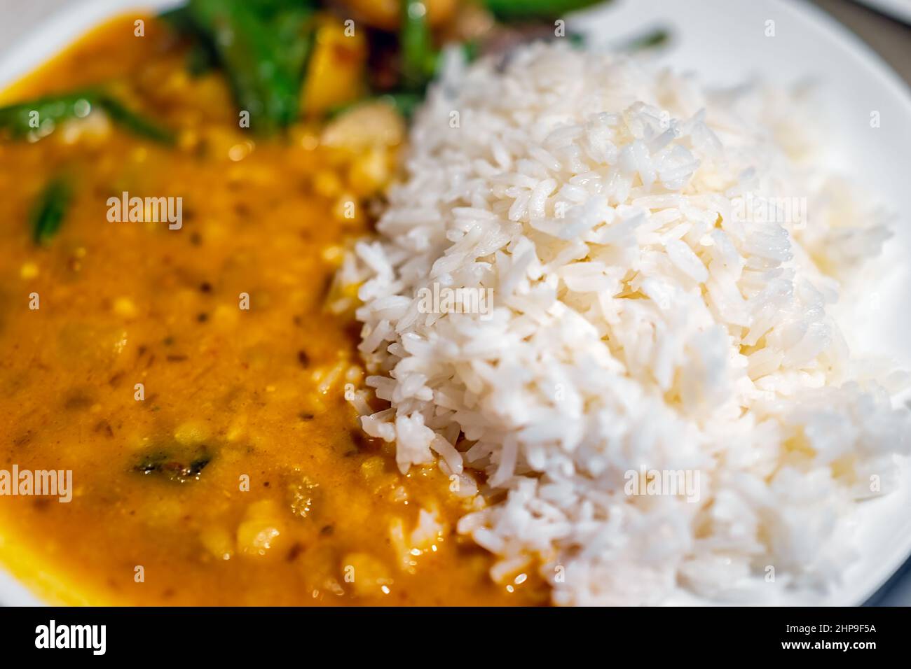 Macro closeup texture of orange red curry healthy coconut squash dal Indian yellow split peas