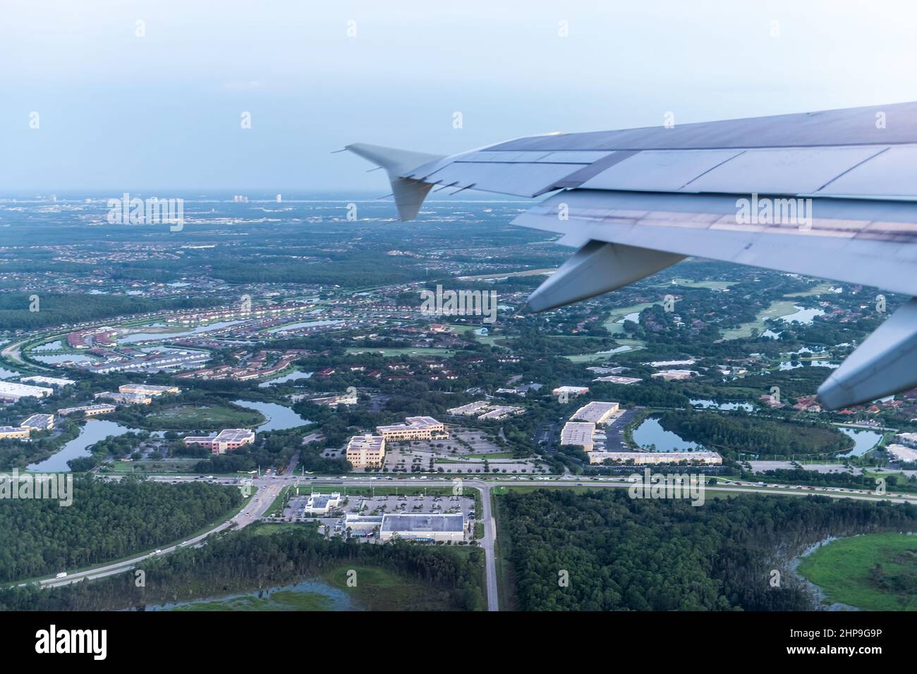 Airplane flying taking off with window aerial point of view of Fort Myers, Florida, USA city town houses and buildings in morning sunrise dawn Stock Photo