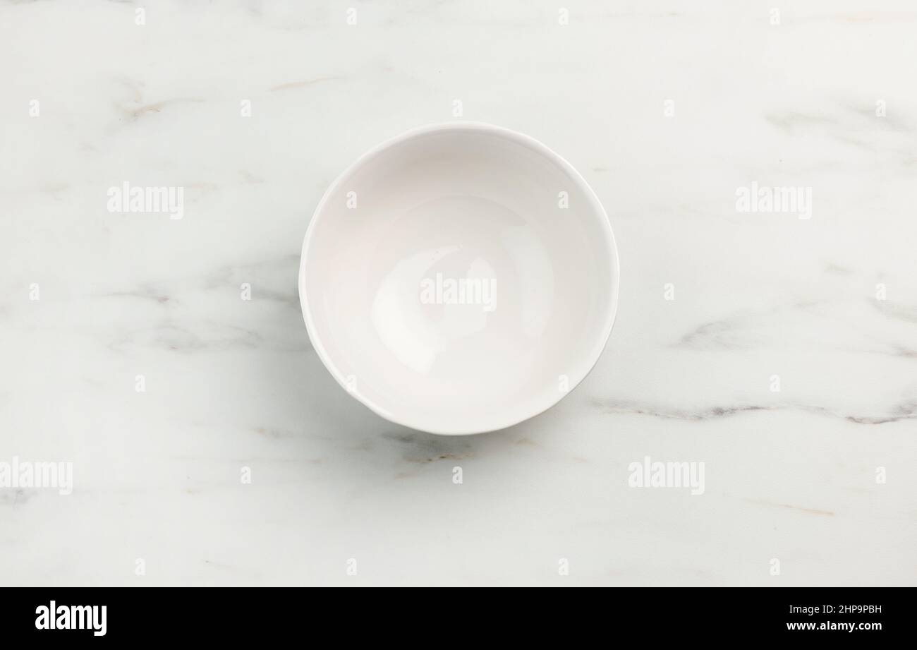 empty white bowl on marble texture kitchen table, top view Stock Photo