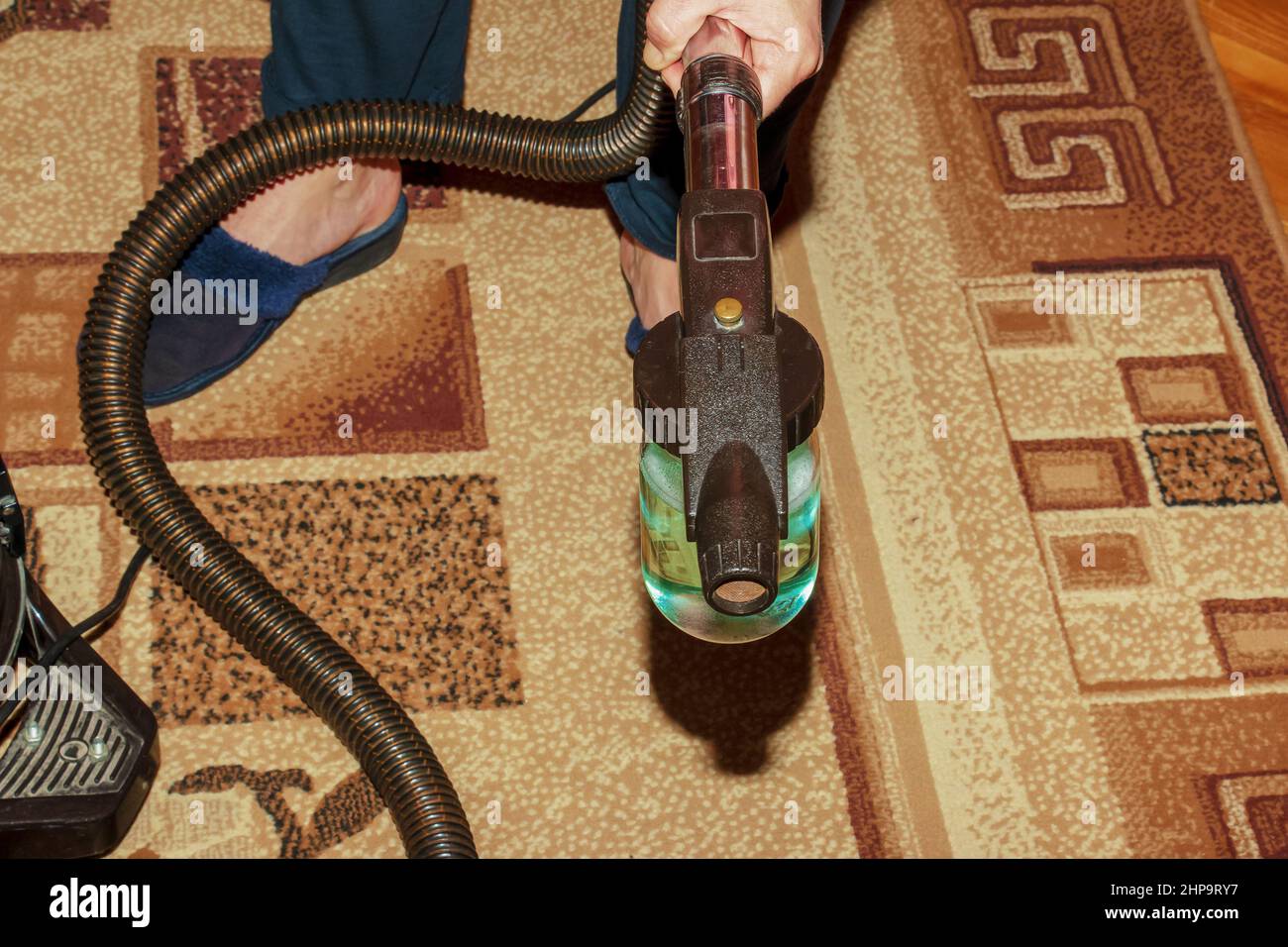 The process of cleaning the carpet with a vacuum cleaner with a water filter. Nozzle for the