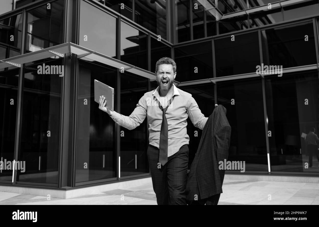 man frustrated by problem. depressed boss outside office with laptop. world economy hit Stock Photo