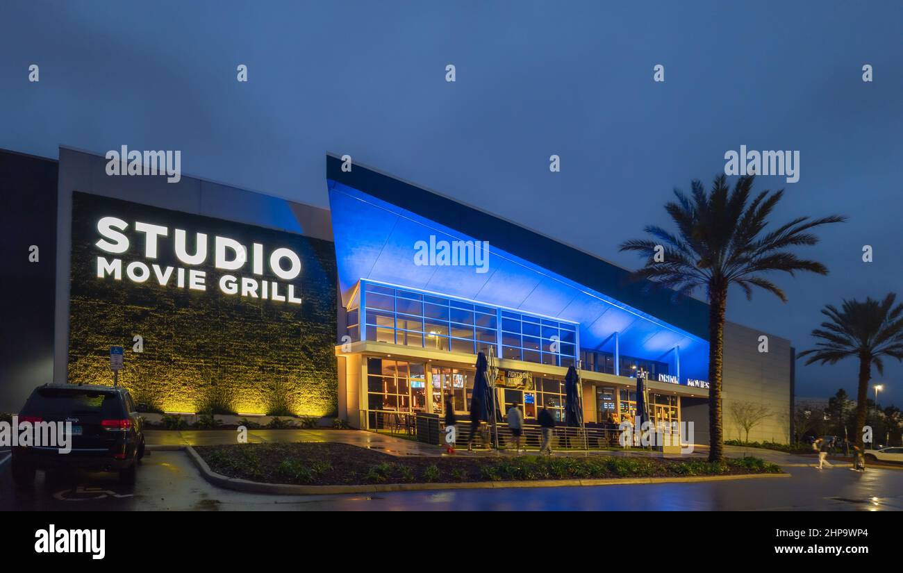 Kissimmee, Florida - February 6, 2022: Night Wide Angle View of Studio Movie Grill Building Exterior. It is a Big Modern Movie Theater. Stock Photo