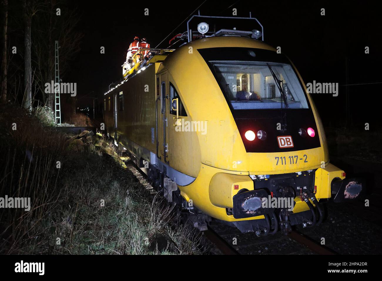 Duesseldorf, Germany. 19th Feb, 2022. Deutsche Bahn employees stand on a special traction unit for the maintenance of overhead lines and repair the live line. The storms knocked down a tree that fell on the overhead line and made this repair necessary. Credit: David Young/dpa/Alamy Live News Stock Photo