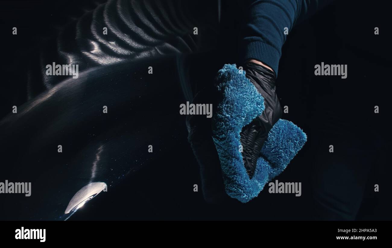 Using rag in palm of your hand, finish liquid car polish are removed