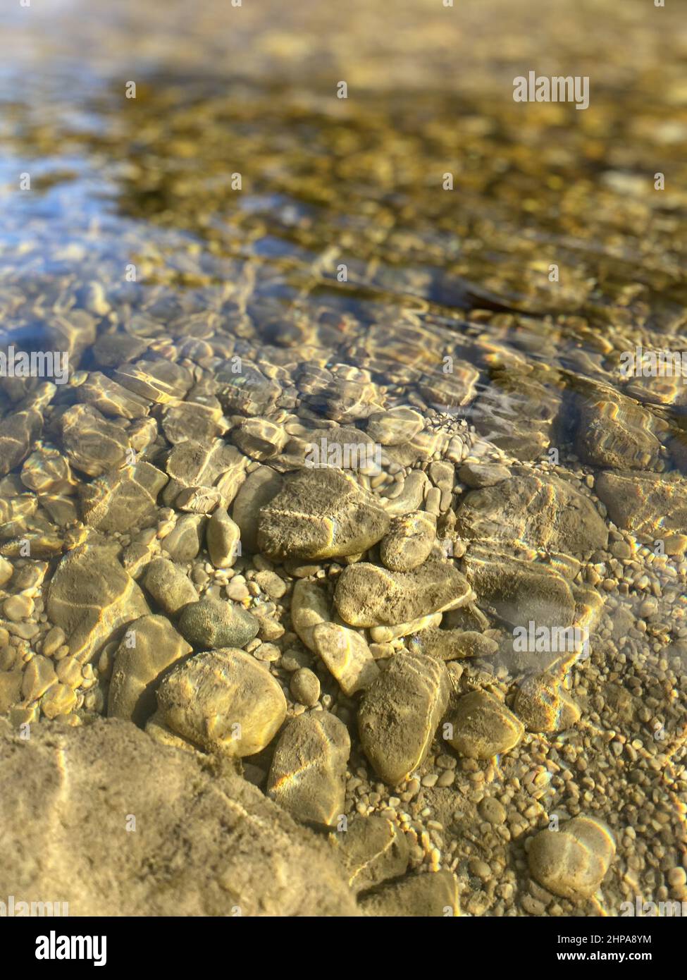Vertical closeup of the small rocks on the bottom of the river Stock ...