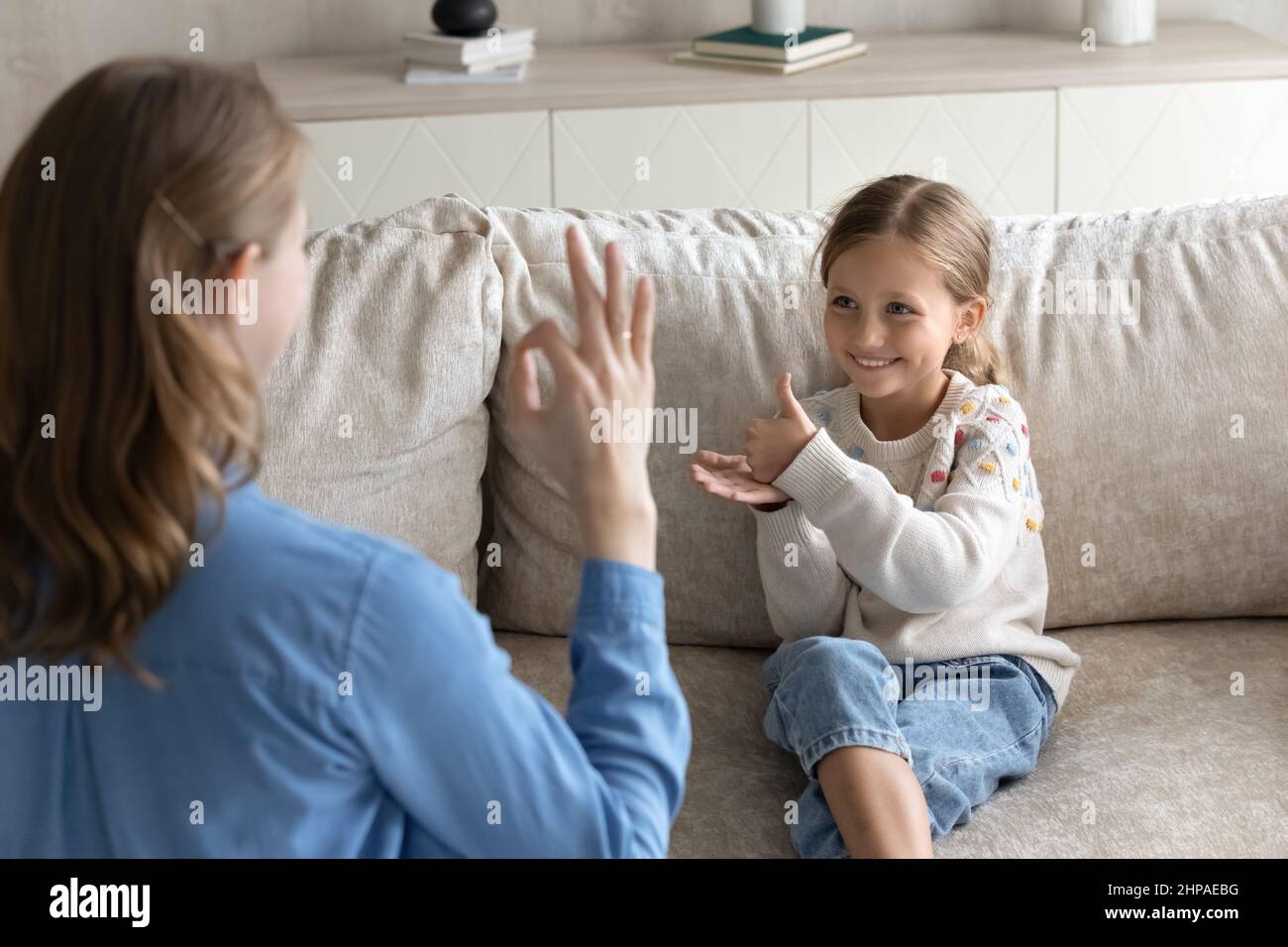 Happy little kid and mom speaking sign language Stock Photo