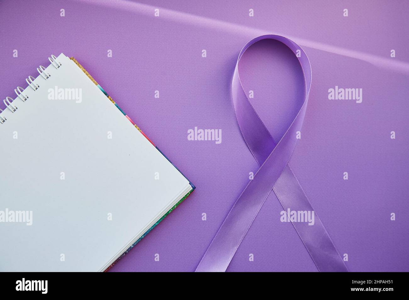 Mock of notepad and purple ribbon for Purple Day - World Epilepsy Day, March of 26. Symbol of Epilepsy Day.  Stock Photo