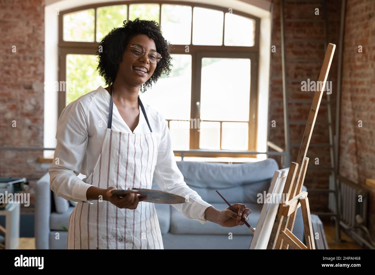 Portrait of creative young African American woman drawing in studio ...