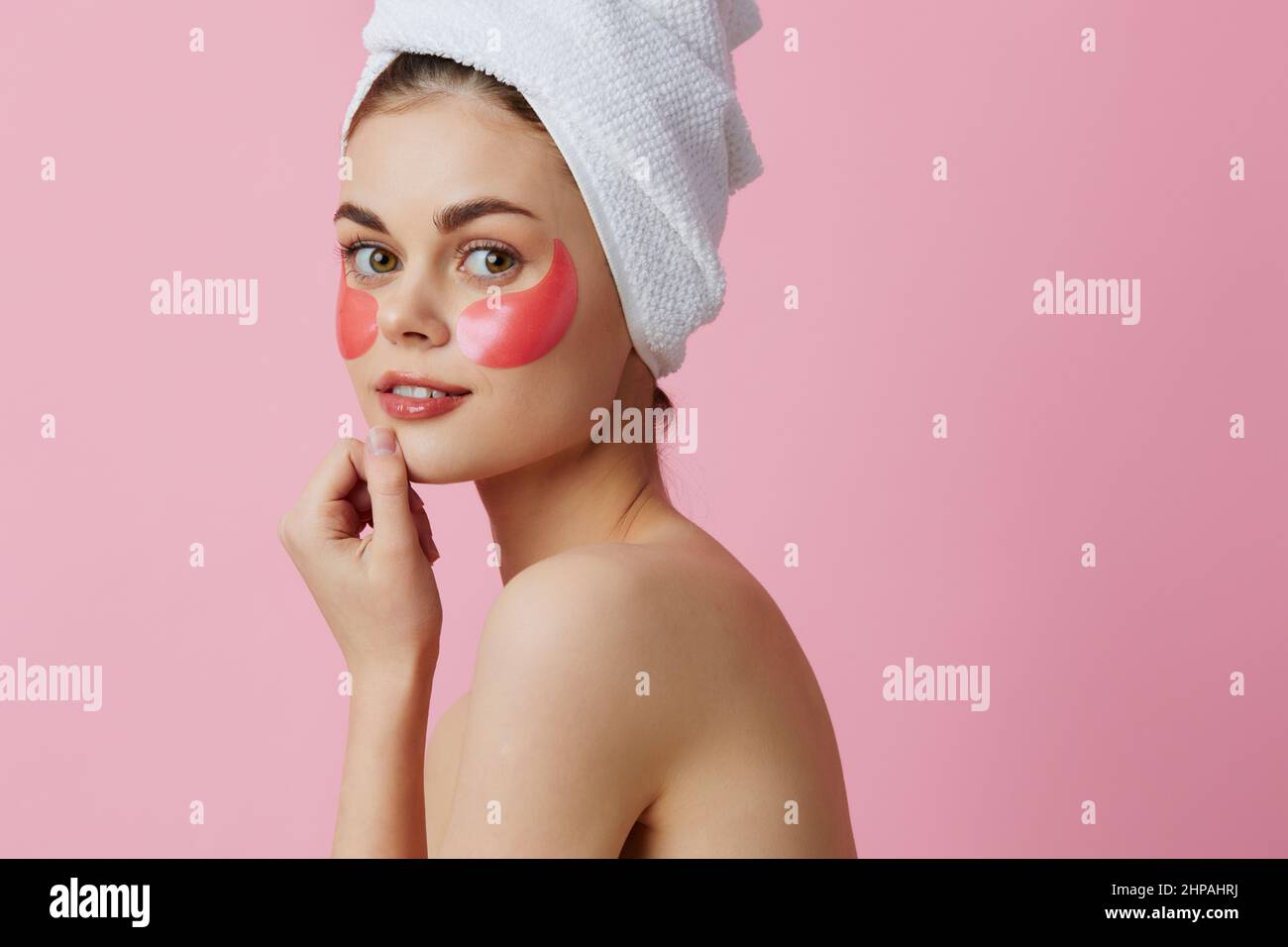 young-woman-pink-patches-on-the-face-with-a-towel-on-the-head-pink
