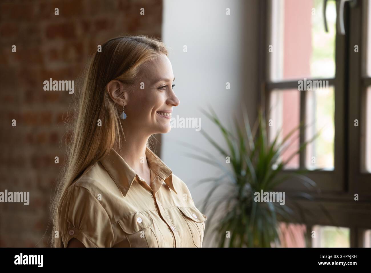 Smiling dreamy beautiful young woman looking in distance. Stock Photo