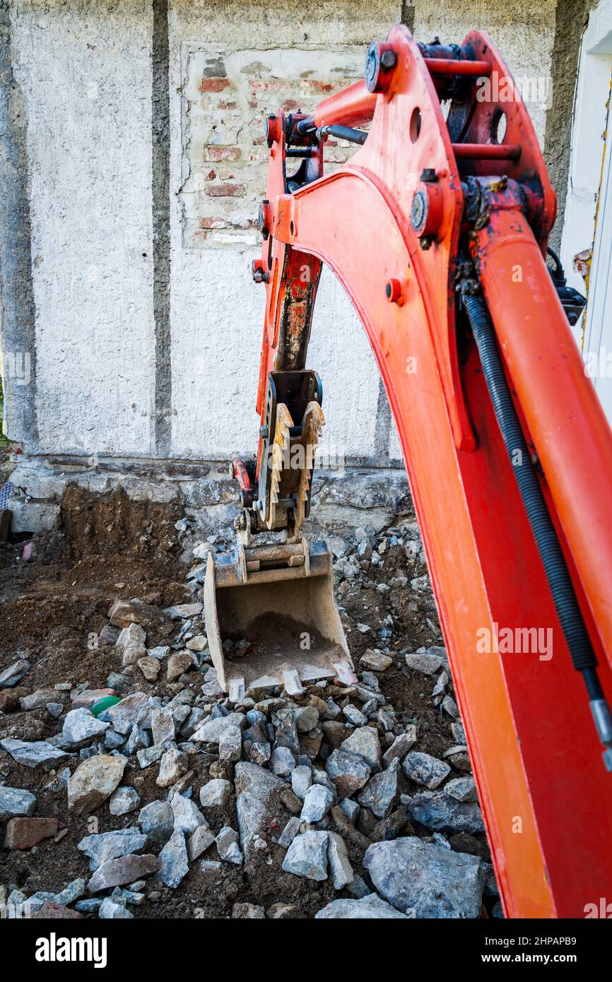 Rebuilding a house and digging dirt with excavator Stock Photo