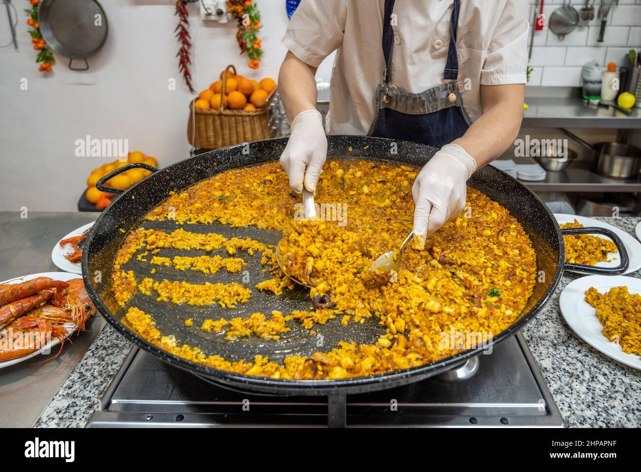 Cook serving a seafood paella (paella de marisco), Valencia, Spain Stock Photo