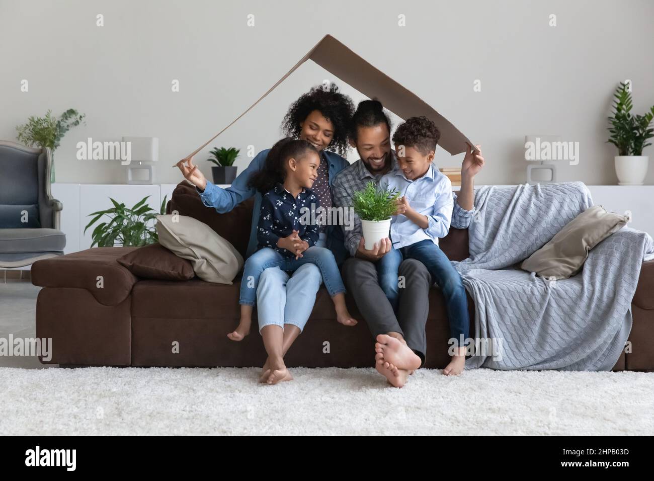 Happy bonding African American family celebrating moving into new home. Stock Photo
