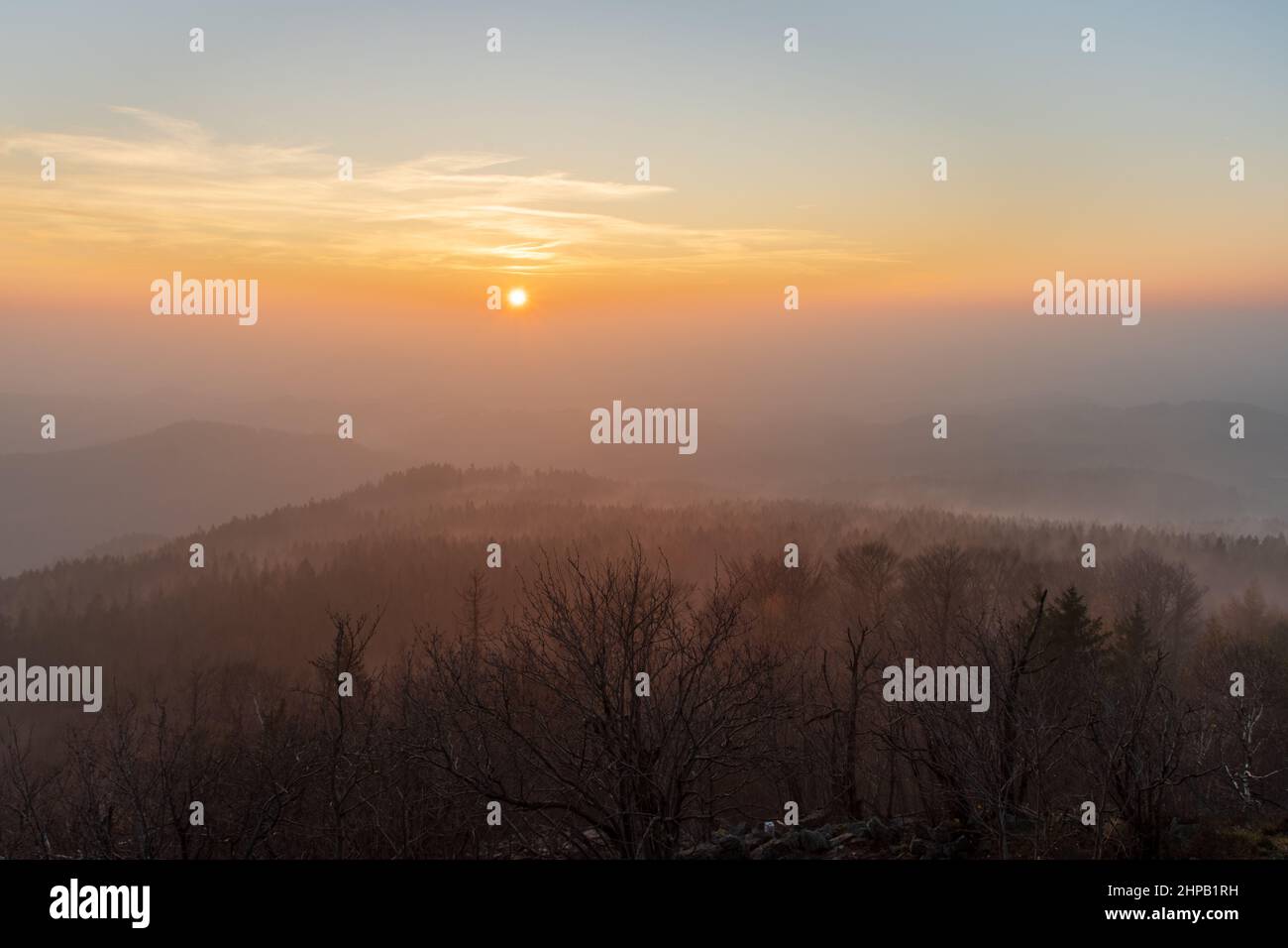 peaks of lusatian mountains in Czech Republic during foggy sunset in winter as seen from mount Hochwald in Germany Stock Photo