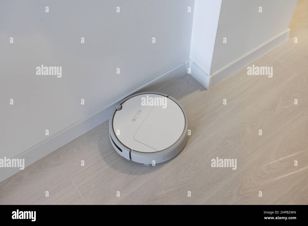 Smart House. Vacuum cleaner robot runs on wood floor in a living room ...