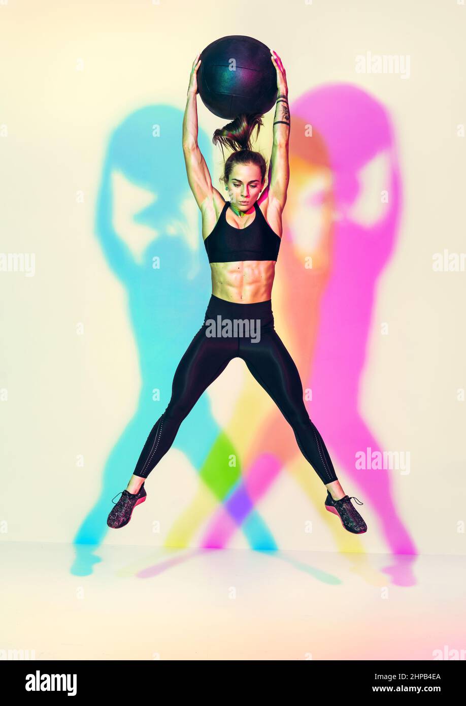 Strong woman does exercise med ball slams with jump. Photo of woman