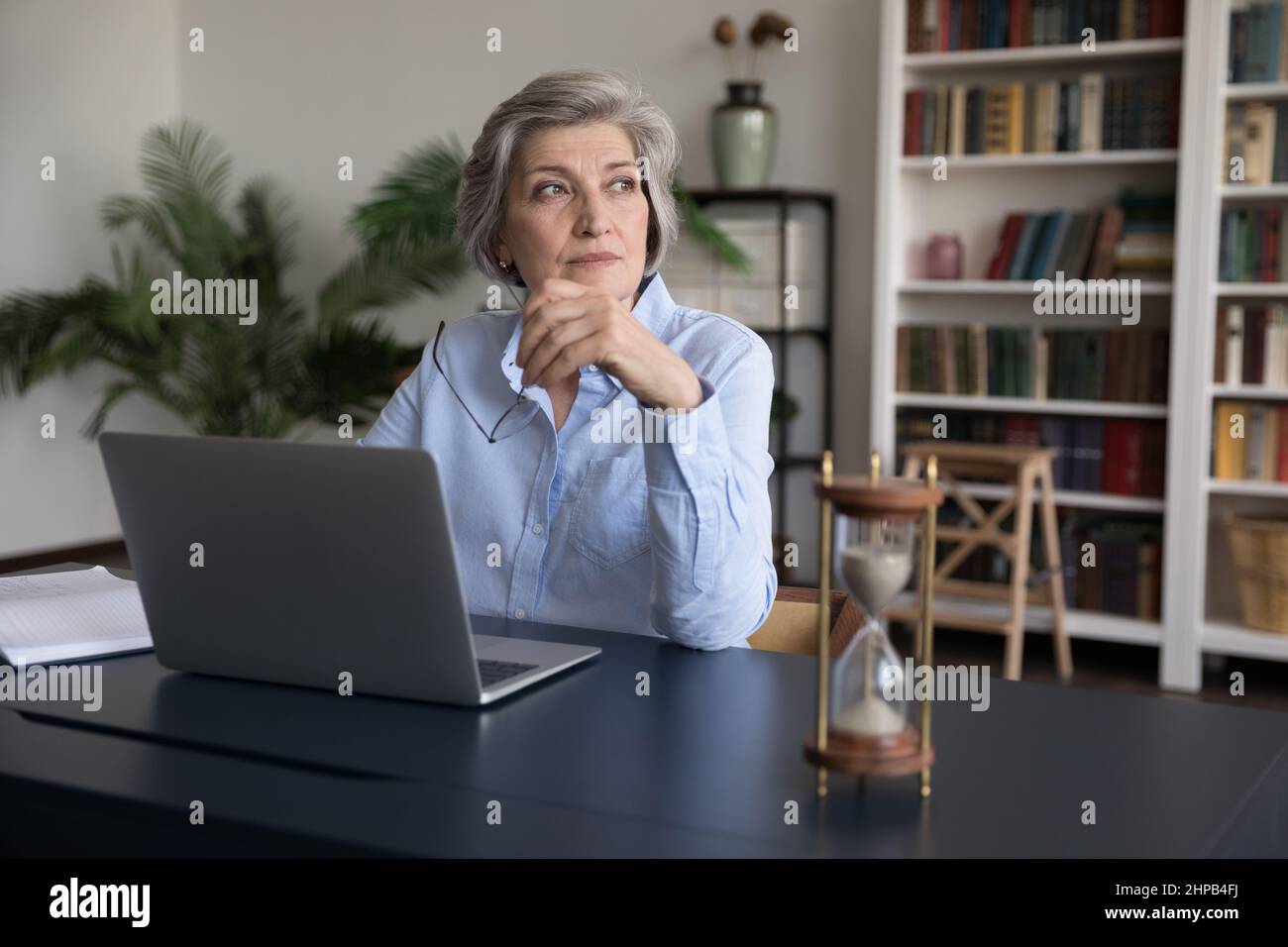 Thoughtful smart middle aged businesswoman working in office. Stock Photo