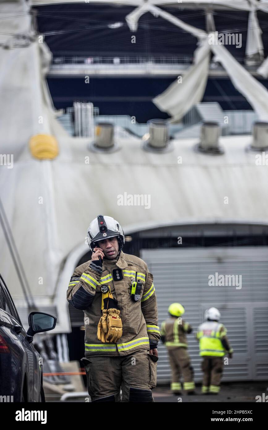 Fireman attend the scene at O2 Arena in East London where the tarpaulin was ripped due to high winds caused by Storm Eunice on Friday 18th Feb 2022 Stock Photo