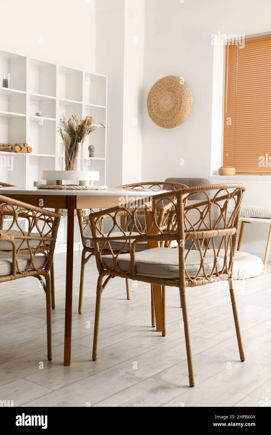 Interior of light dining room with table and shelving unit Stock Photo ...