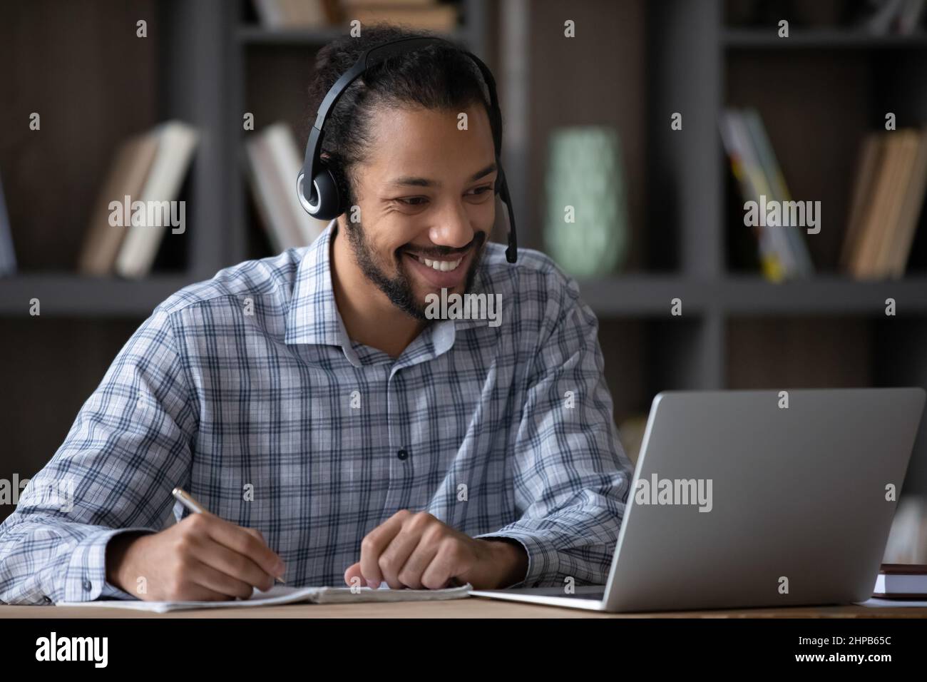 Happy young African American man e-learning using computer. Stock Photo