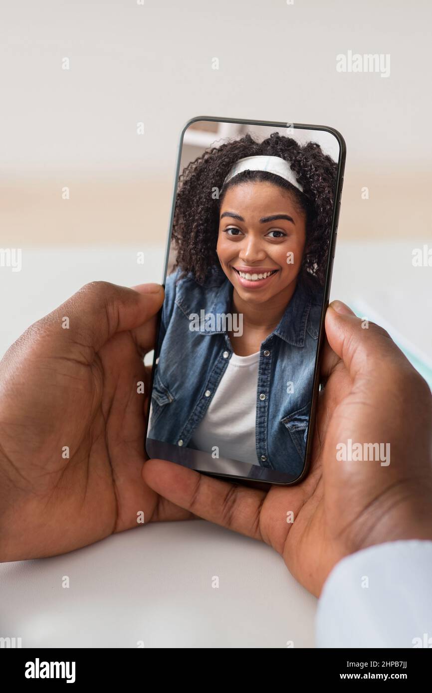 Unrecognizable black man using smartphone, having video call with girlfriend Stock Photo