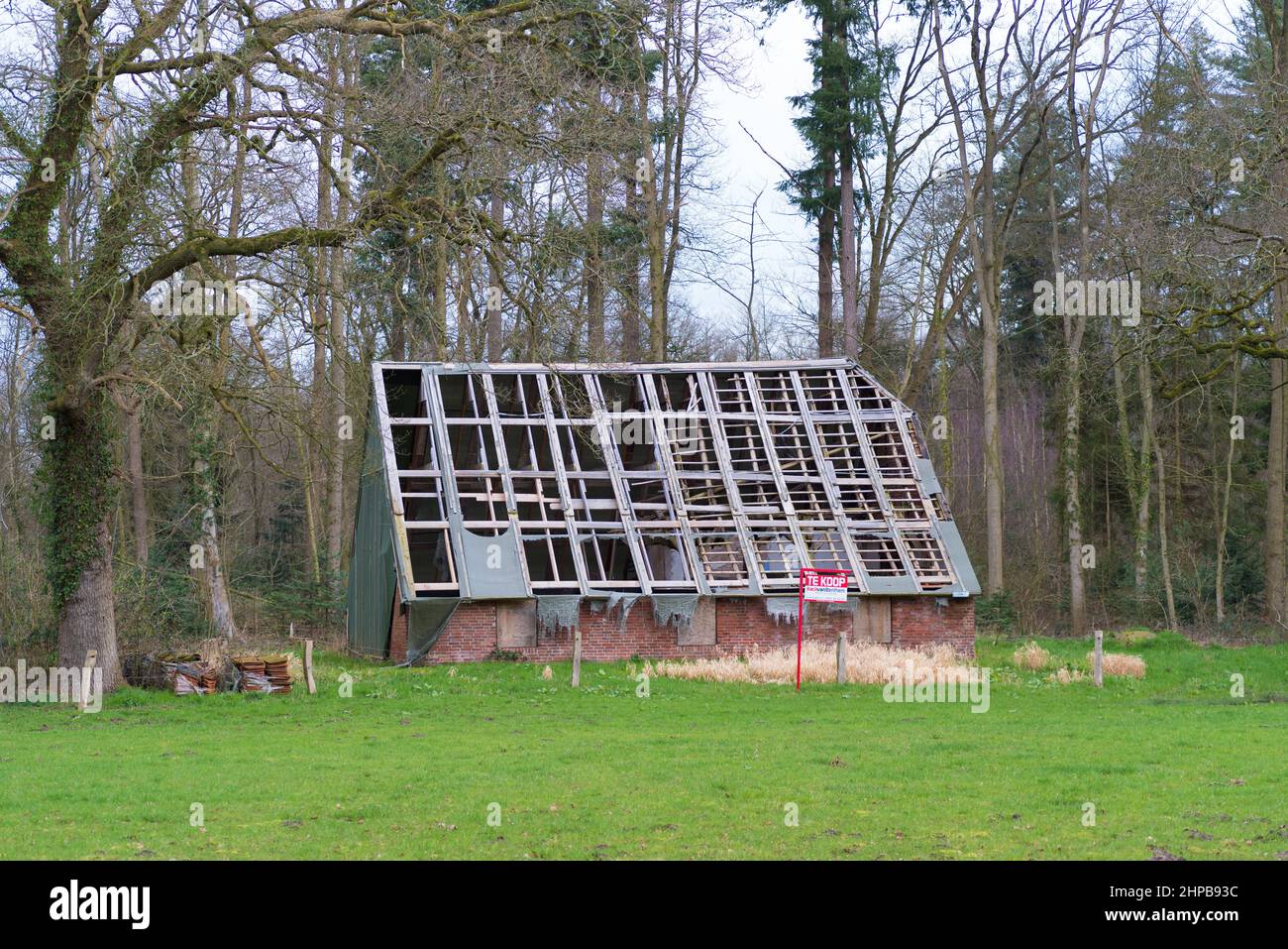 DENEKAMP, NETHERLANDS - MARCH 8, 2020: Old farmhouse with no roof for sale in a rural landscape. Stock Photo