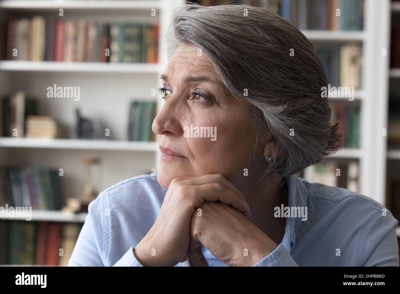 Head shot thoughtful middle aged woman looking in distance. Stock Photo