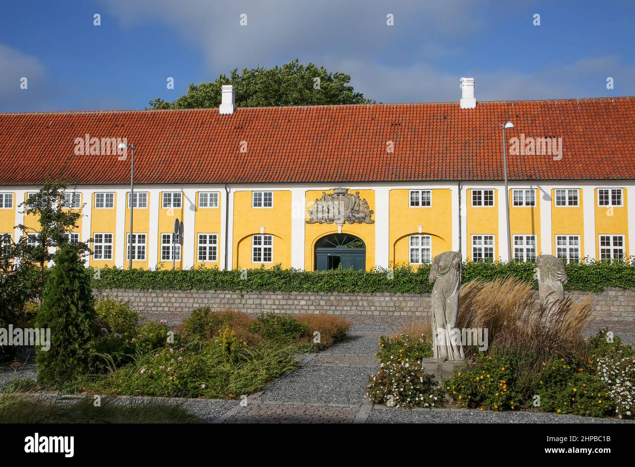 Kaalund Monastery is located in Kalundborg Municipality, Denmark. Historic yellow and white landmark building with gardens in the foreground. Stock Photo