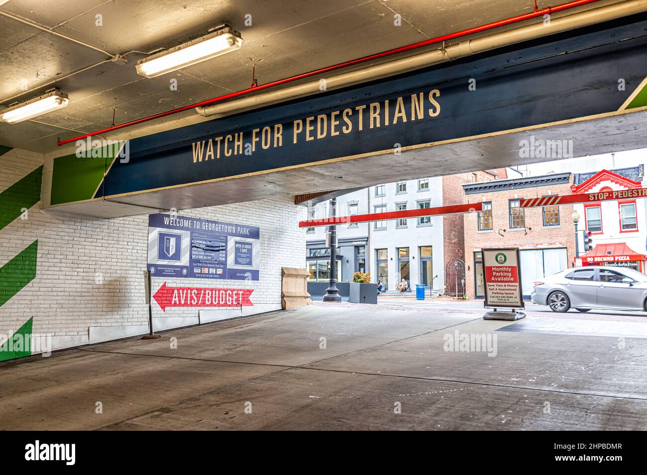 Washington DC, USA - August 18, 2021: Georgetown M street with sign inside public parking garage exit for watch for pedestrians outside Stock Photo