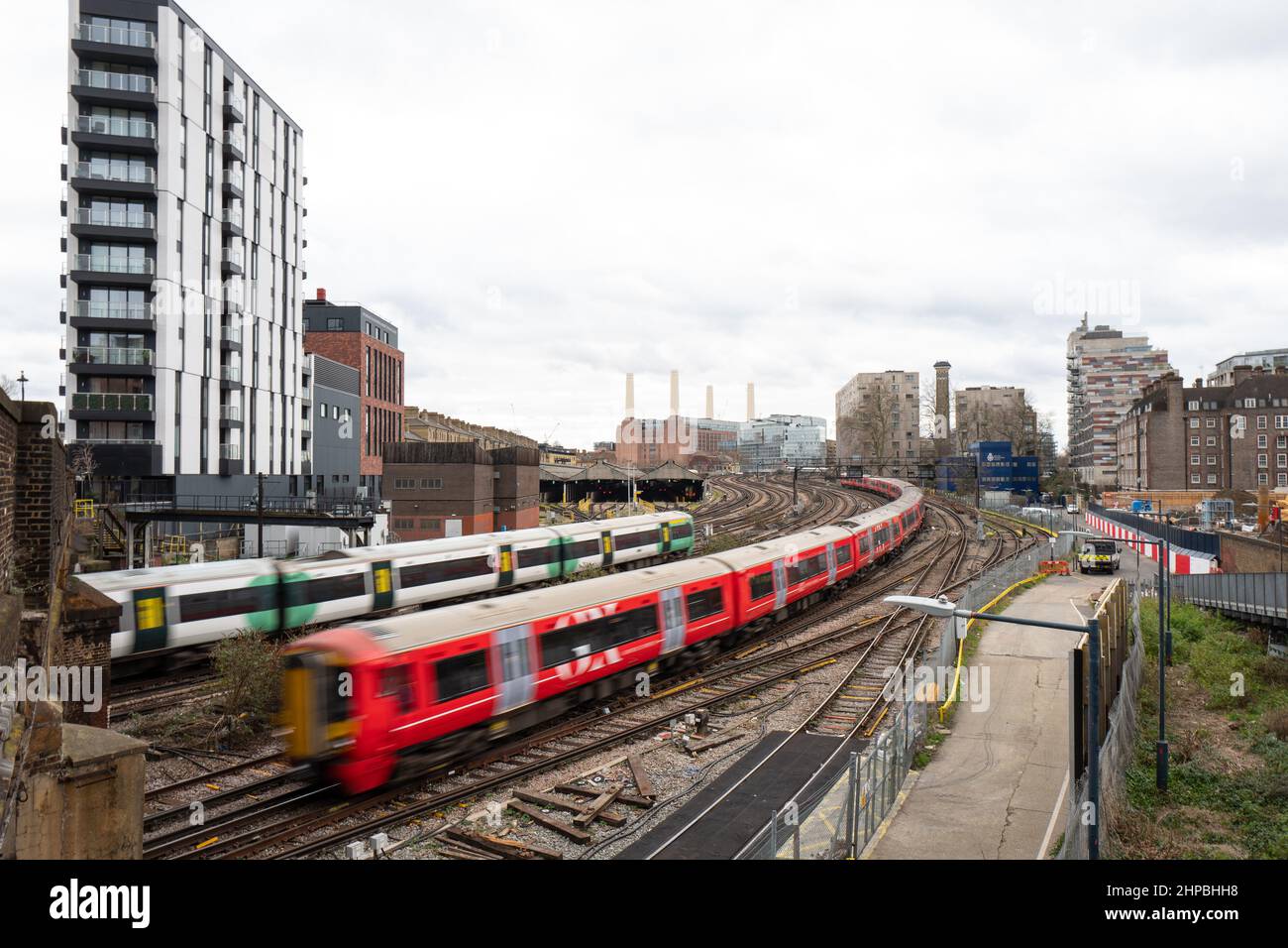 Mainline trains pass each other whilst in the background the iconic Battersea Power Station can be seen. London UK Stock Photo