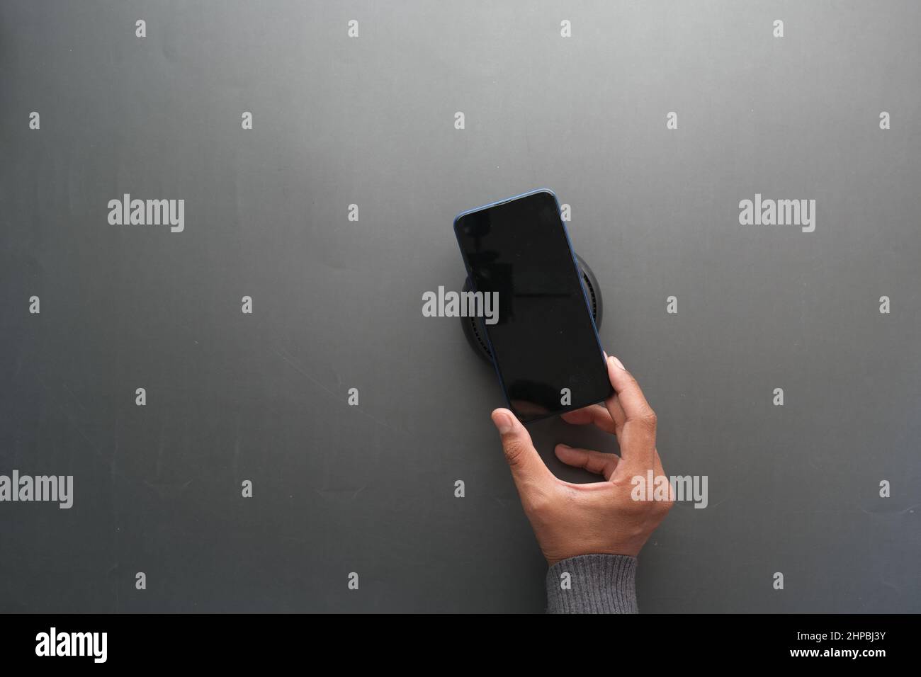 charging Smartphone using Wireless Charging Pad, top view Stock Photo